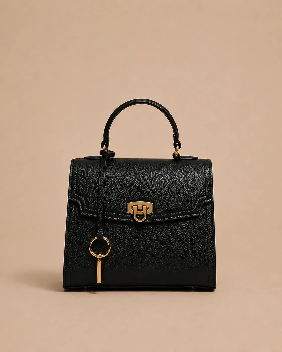 Beatrice genuine leather top handle bag in black featuring structured silhouette, gold-tone hardware, front lock closure and detachable shoulder strap. The Essentials Collection by Malena London.