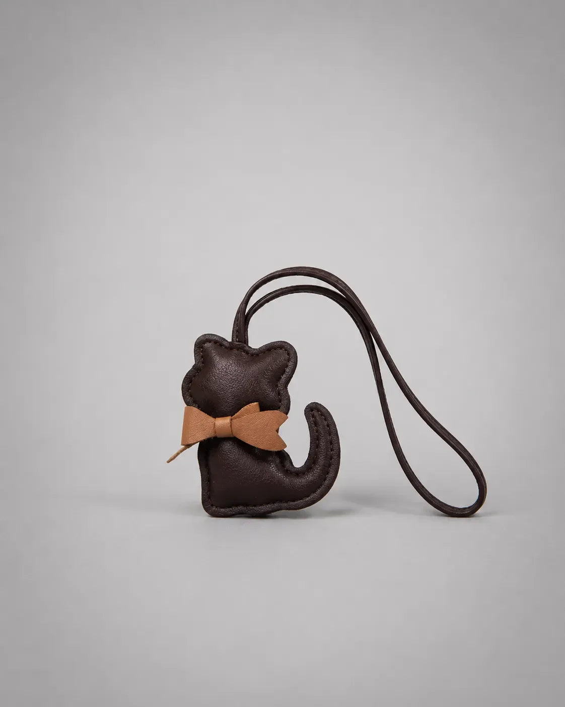Dark chocolate cat bag charm with bow detail and attachment loop displayed on a clean studio background, designed to personalise handbags and accessories.