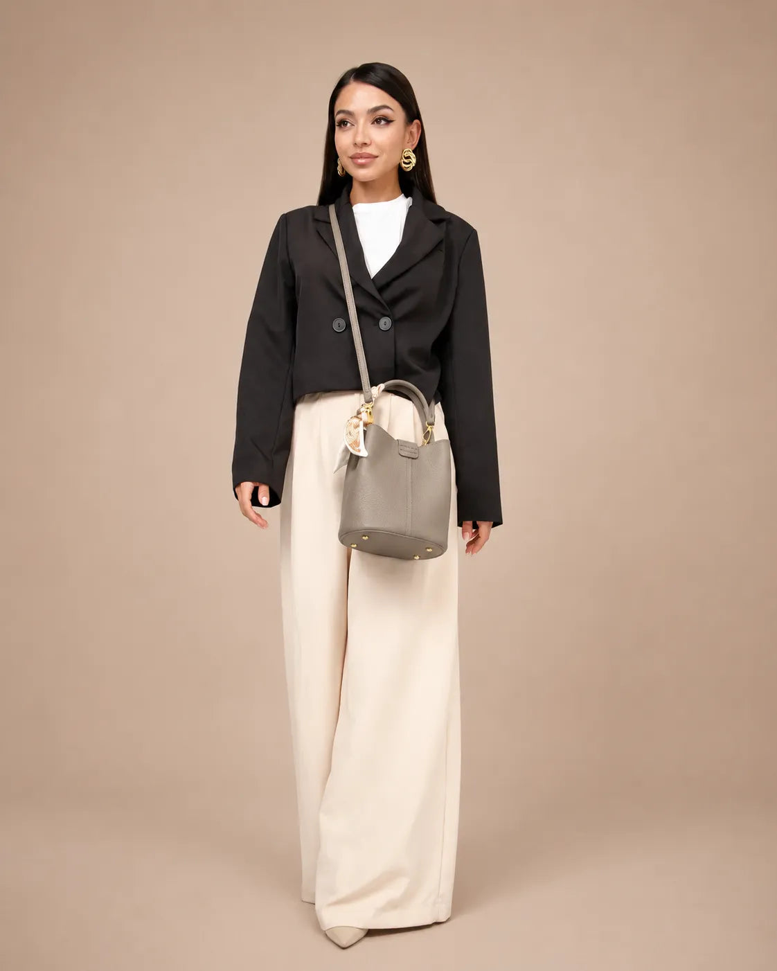 Woman carrying The Charlotte elephant gray genuine leather handbag with a detachable shoulder strap and silk scarf detail. Timeless leather bag for women combining everyday functionality, minimalist design and quiet luxury style.