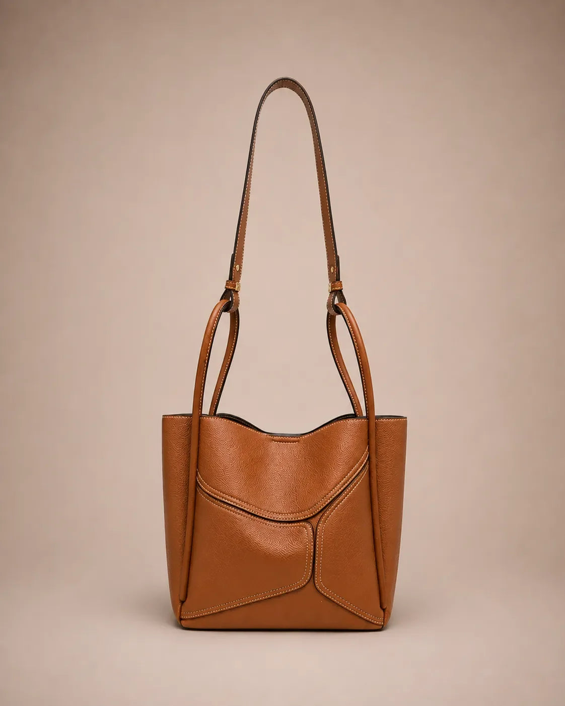 Delphine Leather Shoulder Bag in Cookie genuine leather featuring an architectural front panel design, structured silhouette, top handles and removable shoulder strap. A statement leather handbag by Malena London.