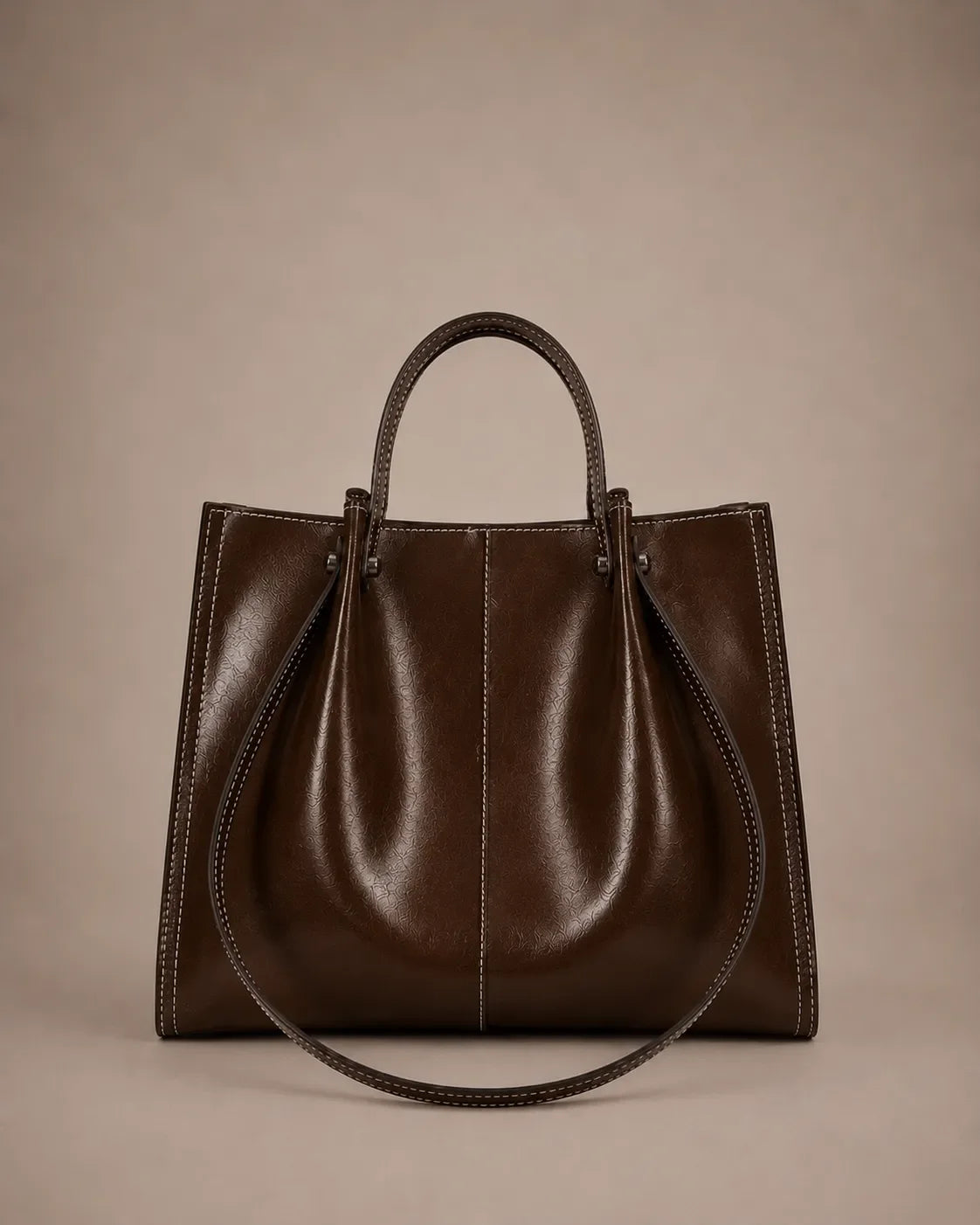Edith Leather Tote Bag in Dark Chocolate genuine leather shown from the front, featuring a structured silhouette, contrast stitching and elegant top handles from The City Edit collection by Malena London.