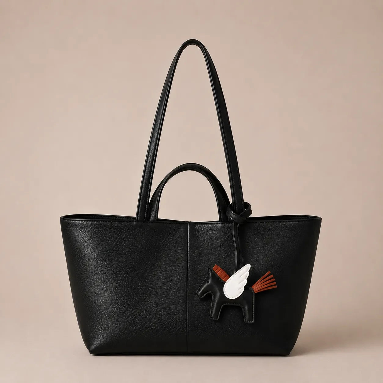 Leather bag charm accessory attached to a premium black tote bag for elegant handbag personalisation by Malena London