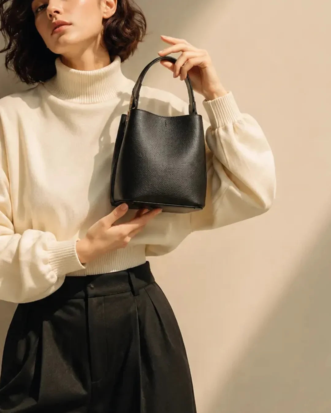 Close-up of The Bonnie genuine leather bucket bag, showcasing its refined pebbled leather, softly structured silhouette, minimalist design and elegant everyday versatility.