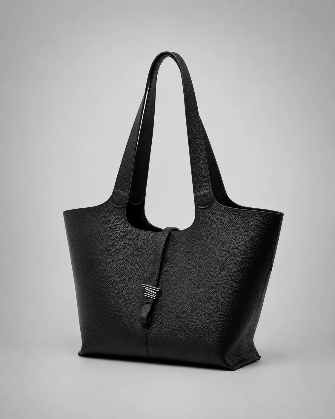 Victoria genuine leather work tote bag in black shown from a front angle, featuring a spacious silhouette, long shoulder straps and a refined minimalist design for commuting and everyday city life.