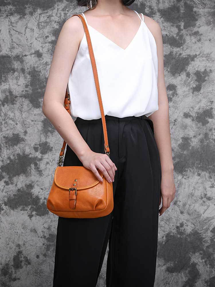 Model wearing the vintage genuine leather shoulder bag in tan across the body, styled with a white camisole and black trousers, by Malena London
