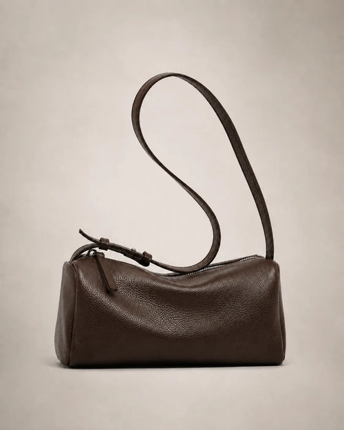 Side view of the Simone genuine leather cylindrical crossbody bag in brown showing the barrel silhouette and adjustable strap.