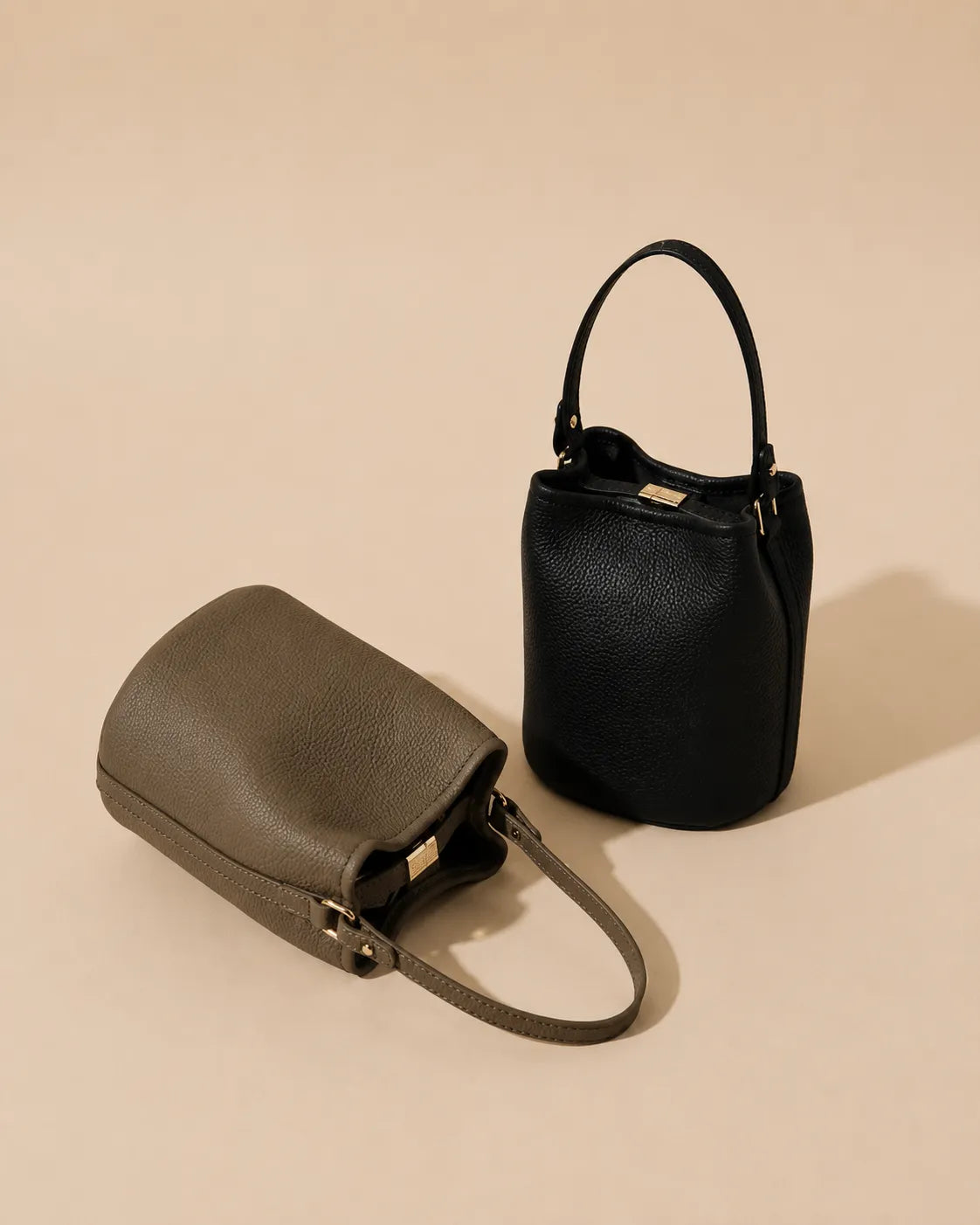 Bonnie genuine leather bucket bag displayed in Black and Dark Grey, showcasing the timeless bucket silhouette and premium pebbled leather finish