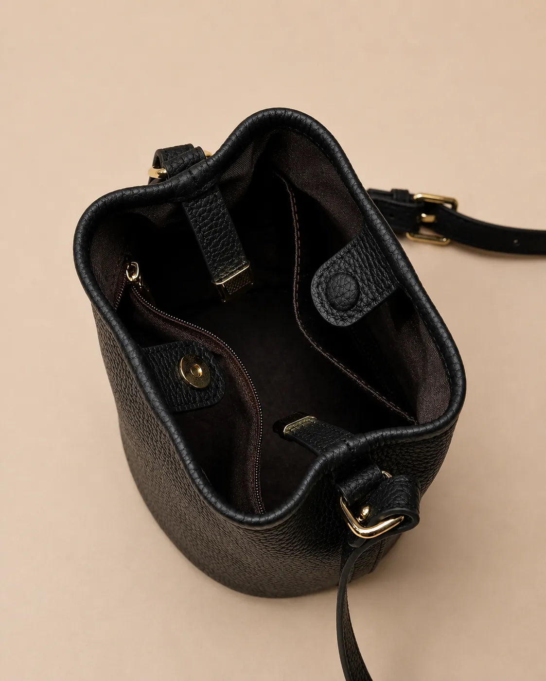 Interior view of the Bonnie genuine leather bucket bag in Black featuring fabric lining, internal compartments, zip pocket and magnetic closure