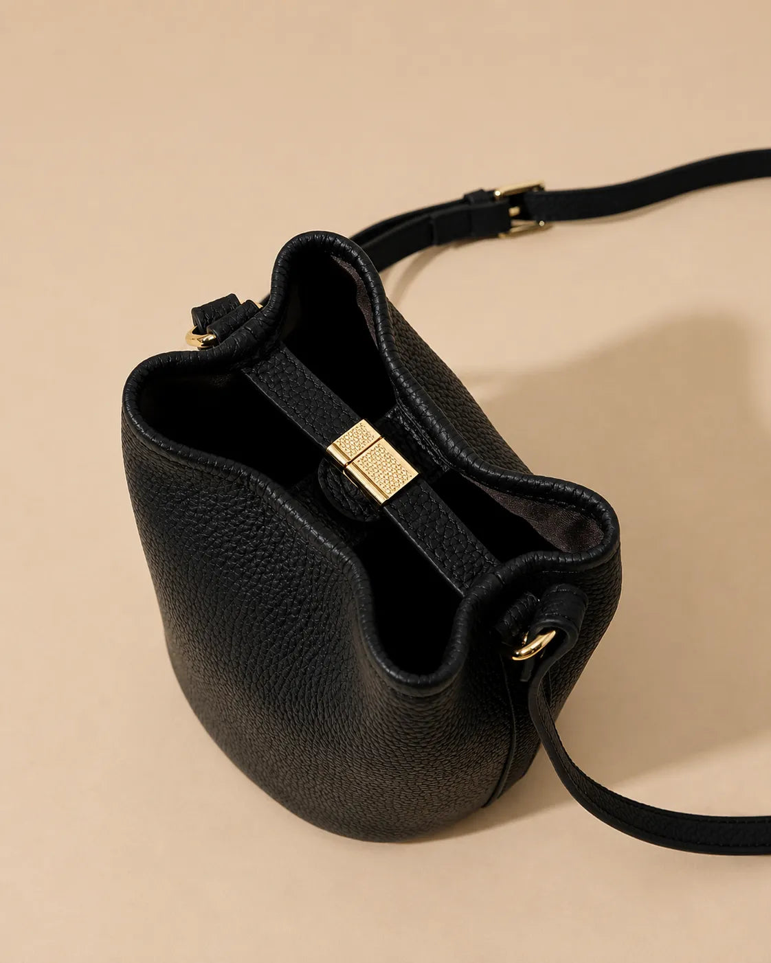 Top view detail of the Bonnie genuine leather bucket bag in Black featuring the structured opening, premium pebbled leather texture and gold-tone closure hardware