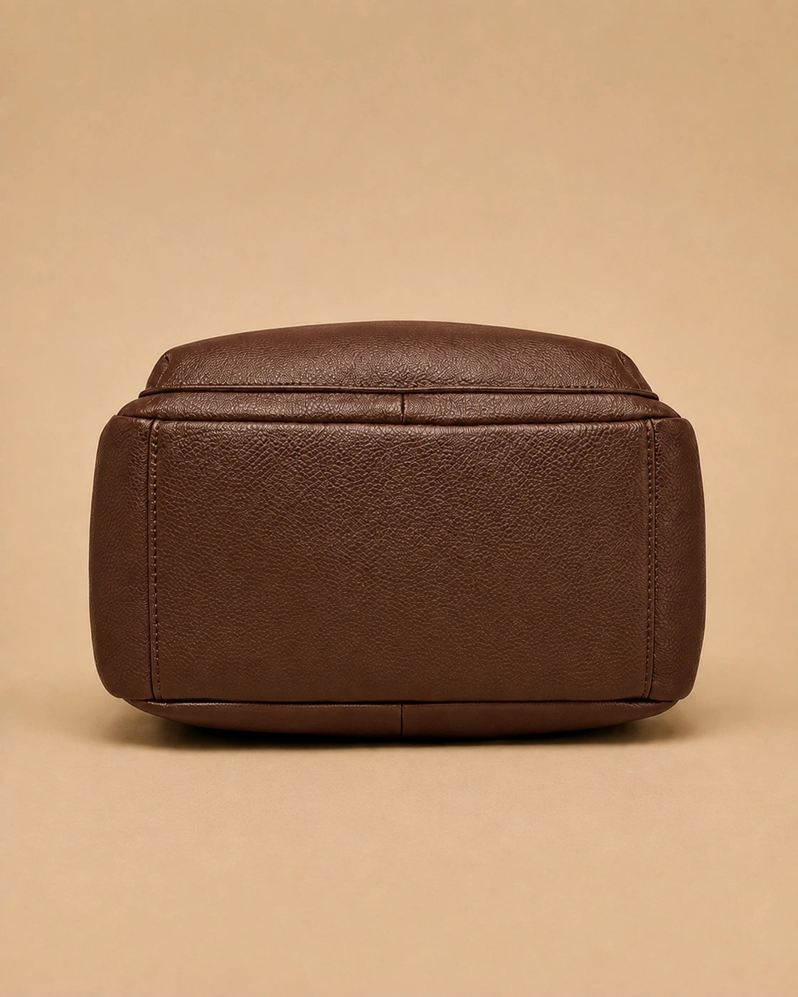 Detail view of the Sloane leather backpack's stitching and leather texture.
