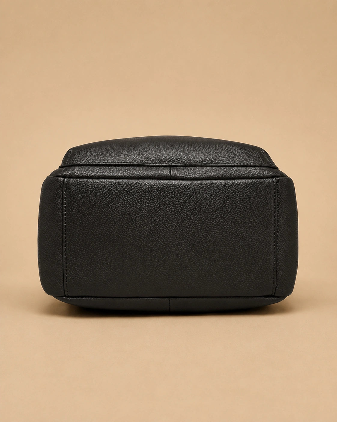 Sloane leather backpack shown carried by the top handle.