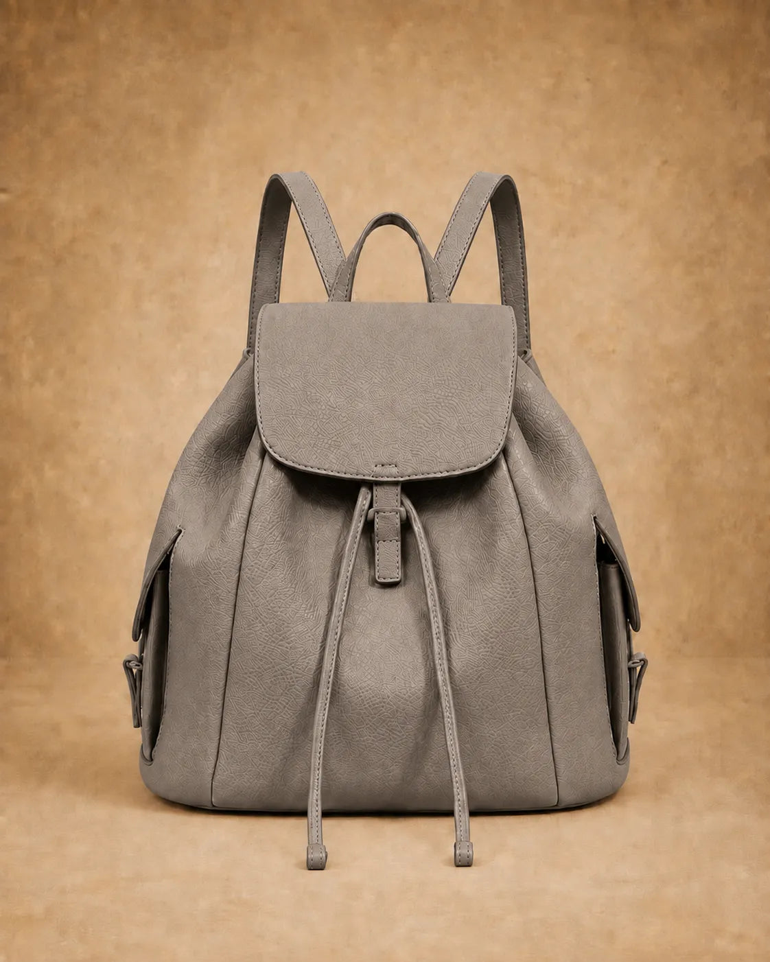 Genevieve leather backpack shown carried by hand.