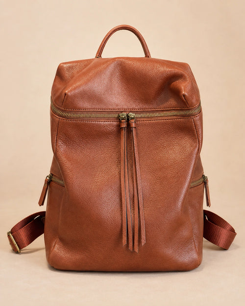 Adeline leather backpack shown carried by hand.
