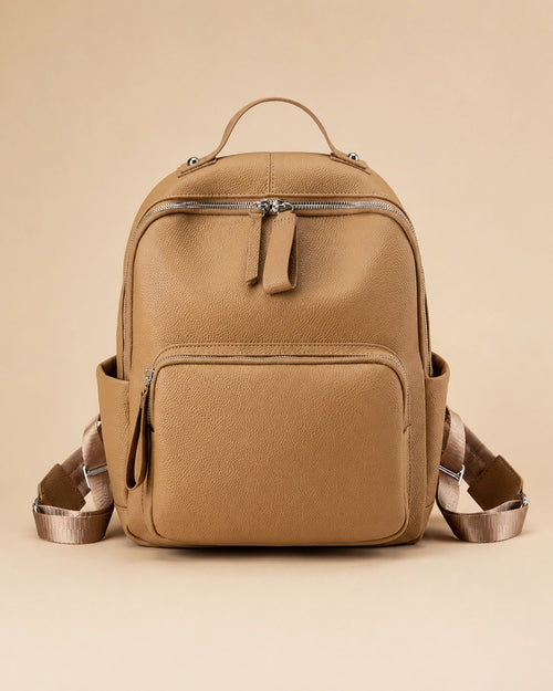 Josephine leather backpack shown carried by hand.