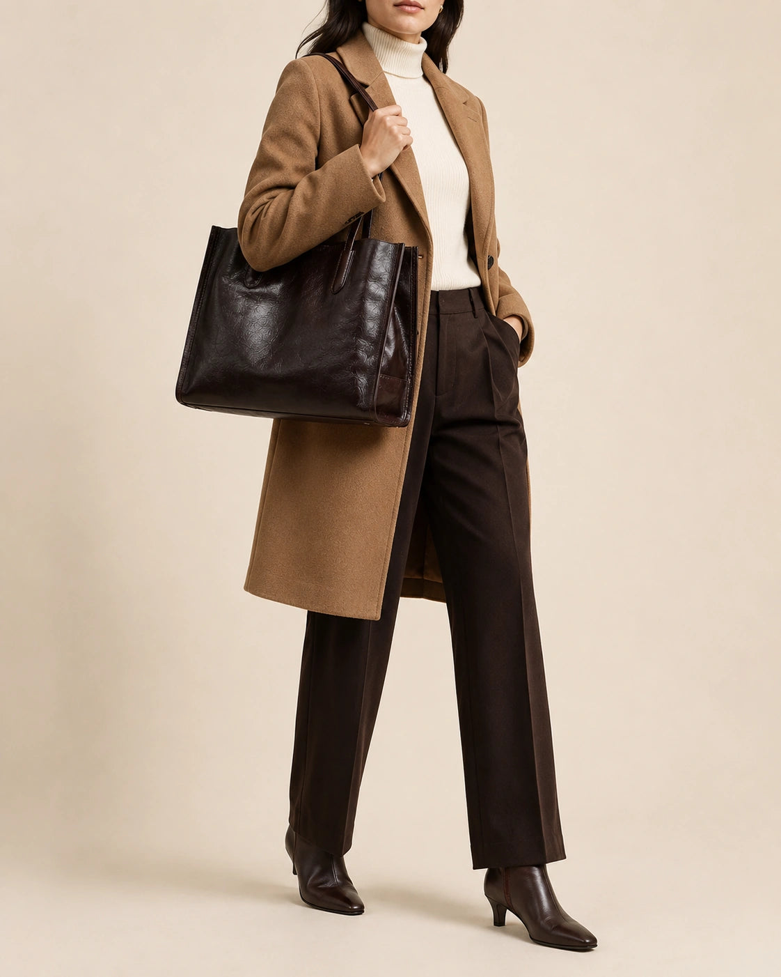 Woman wearing a camel coat carrying the Juliette large genuine leather tote bag in dark chocolate on the shoulder
