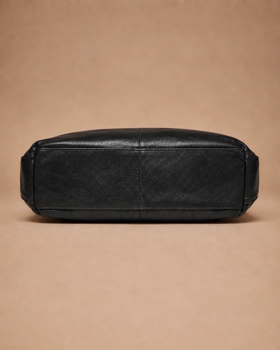 Close-up of the Marlowe genuine leather crossbody bag showing the strap attachment hardware.