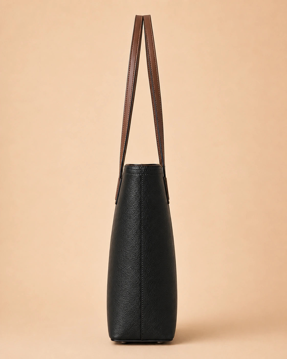 The Sienna genuine leather tote bag carried by hand, showing the double shoulder straps.
