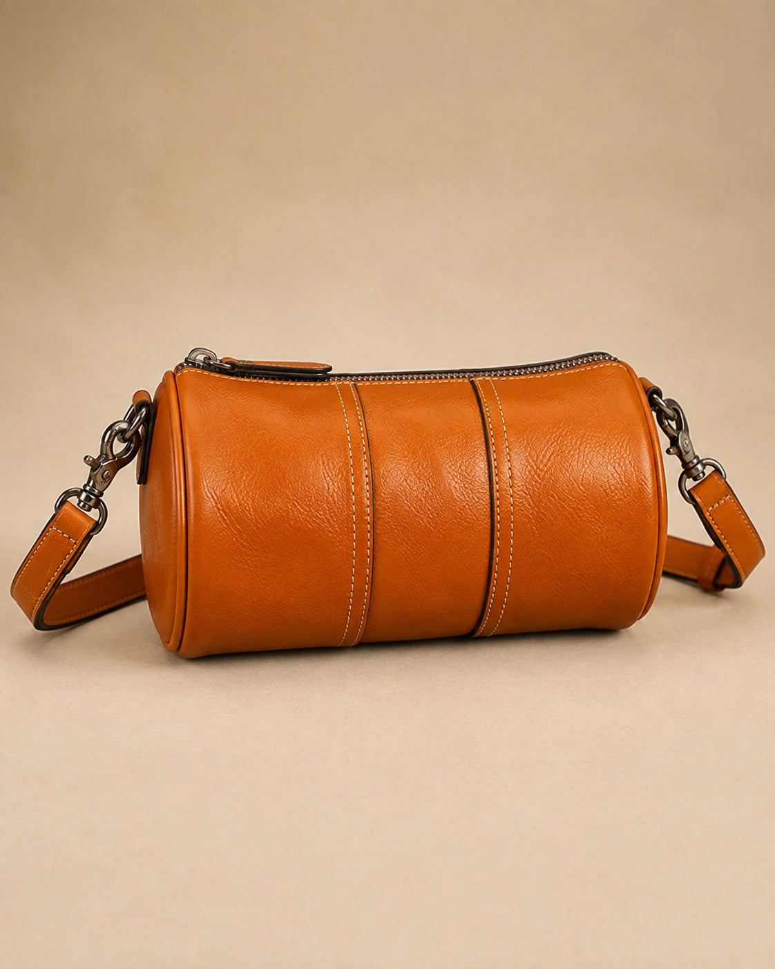 Front view of the Romy genuine leather barrel bag showing the rounded cylindrical silhouette.