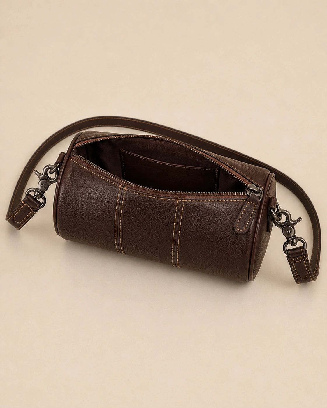 Close-up of the Romy genuine leather barrel bag showing the shoulder strap attachment.