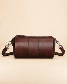 Side view of the Romy genuine leather barrel bag showing the zip closure
