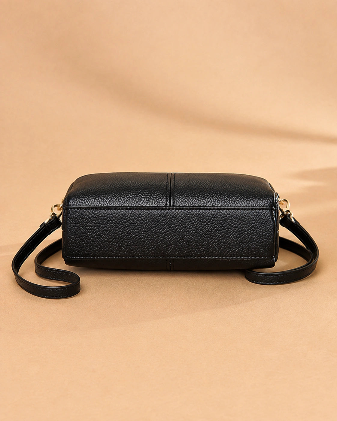 Etta leather crossbody bag shown with the zip closure open.