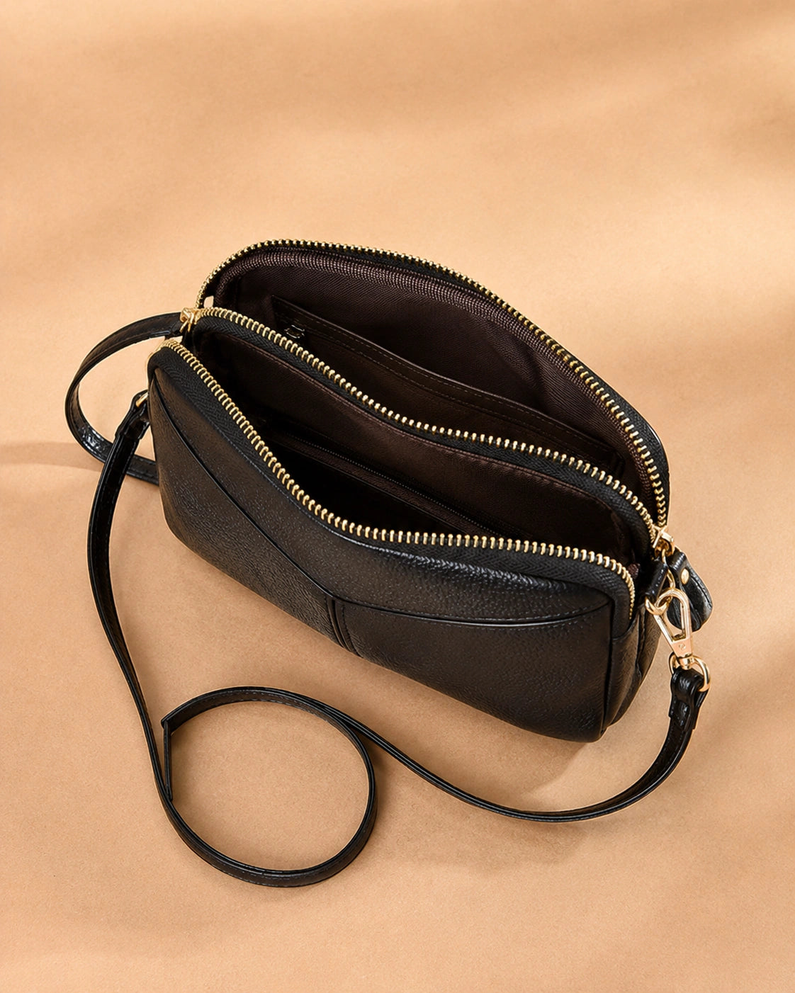 Detail view of the Etta leather crossbody bag's stitching and leather texture.