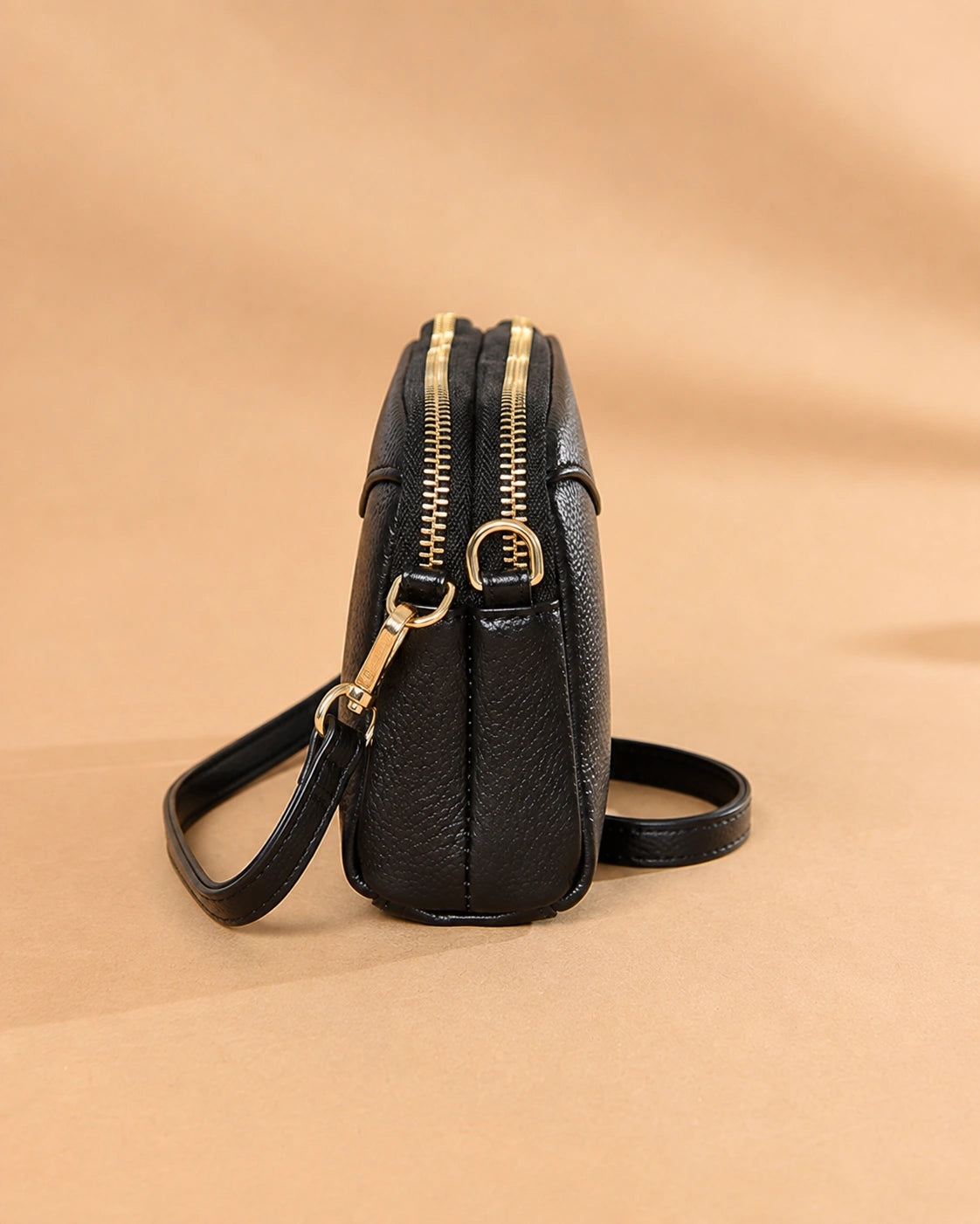 Side view of the Etta leather crossbody bag highlighting the compact shape.