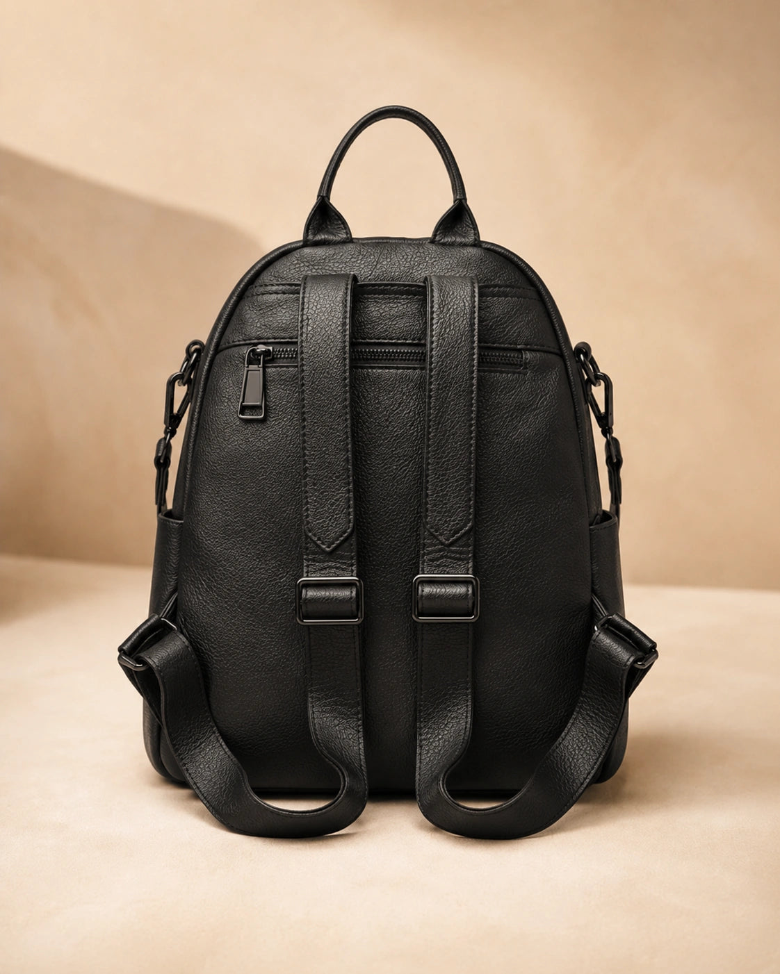 Back view of the Isla lightweight genuine leather travel backpack in black showing the adjustable straps