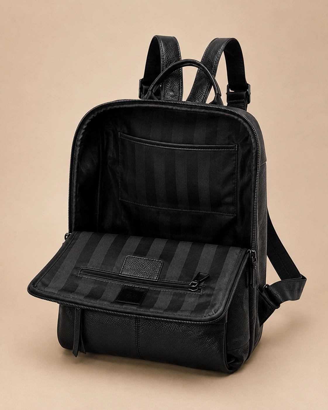 Front pocket detail of the Cecily genuine leather backpack in black showing the laptop pocket open