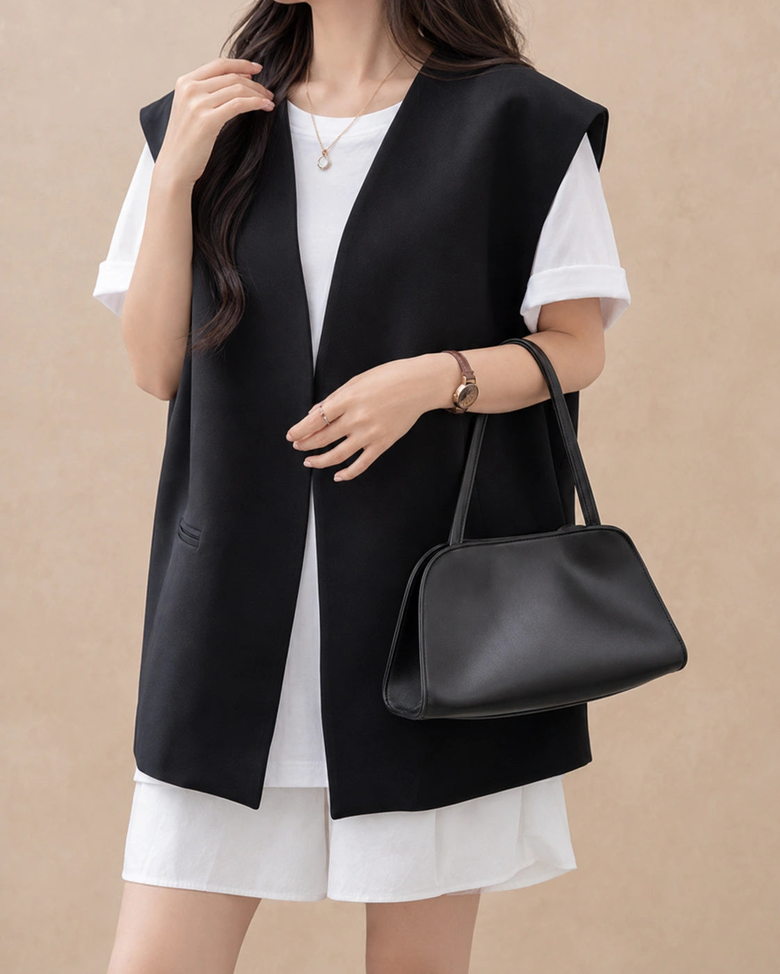 Woman wearing the Corinne genuine leather commuter handbag in black on the shoulder, close view