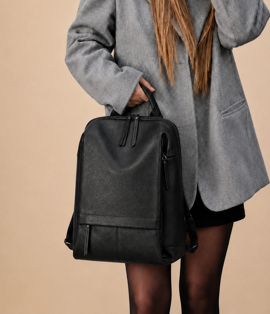 Woman wearing the Cecily genuine leather backpack with laptop pocket in black on the shoulder