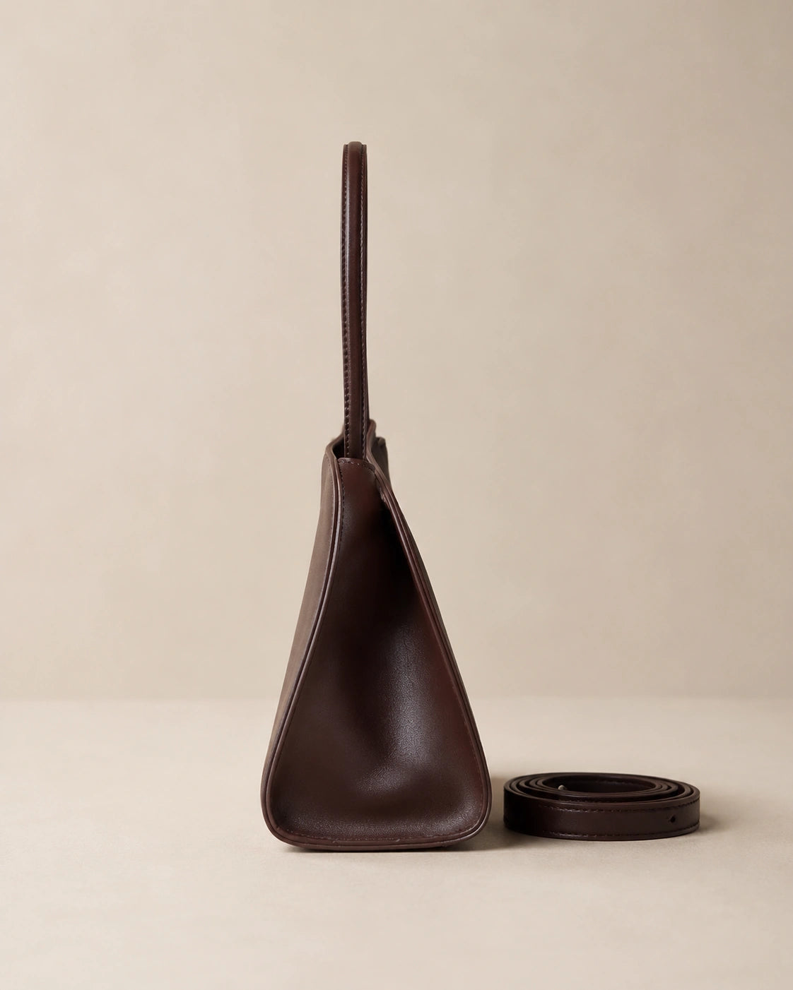 Side view of the Corinne genuine leather commuter handbag in coffee with the shoulder strap
