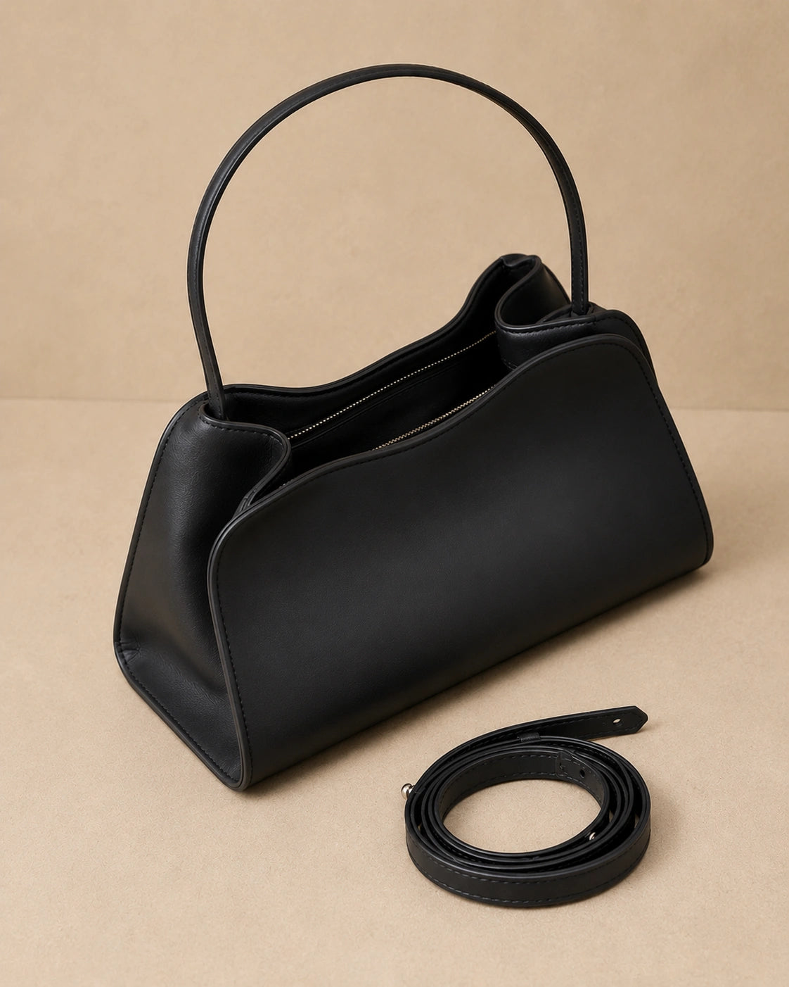 Angled front view of the Corinne genuine leather commuter handbag in black with the shoulder strap