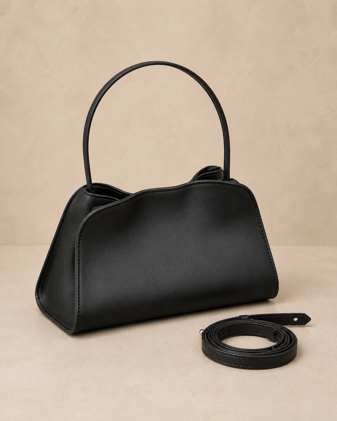 Angled front view of the Corinne genuine leather commuter handbag in black with the shoulder strap attached