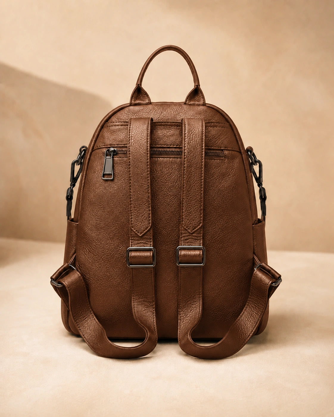 Back view of the Isla lightweight genuine leather travel backpack in brown showing the adjustable straps