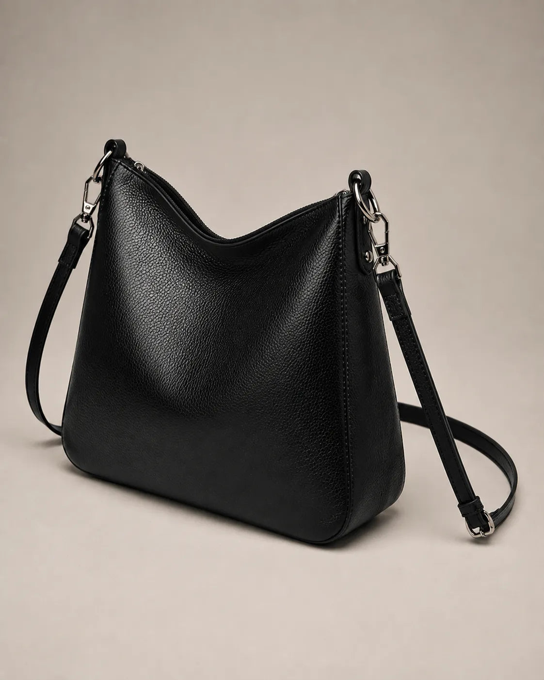 Three-quarter view of the Noémie soft genuine leather hobo shoulder bag in black showing the relaxed silhouette.