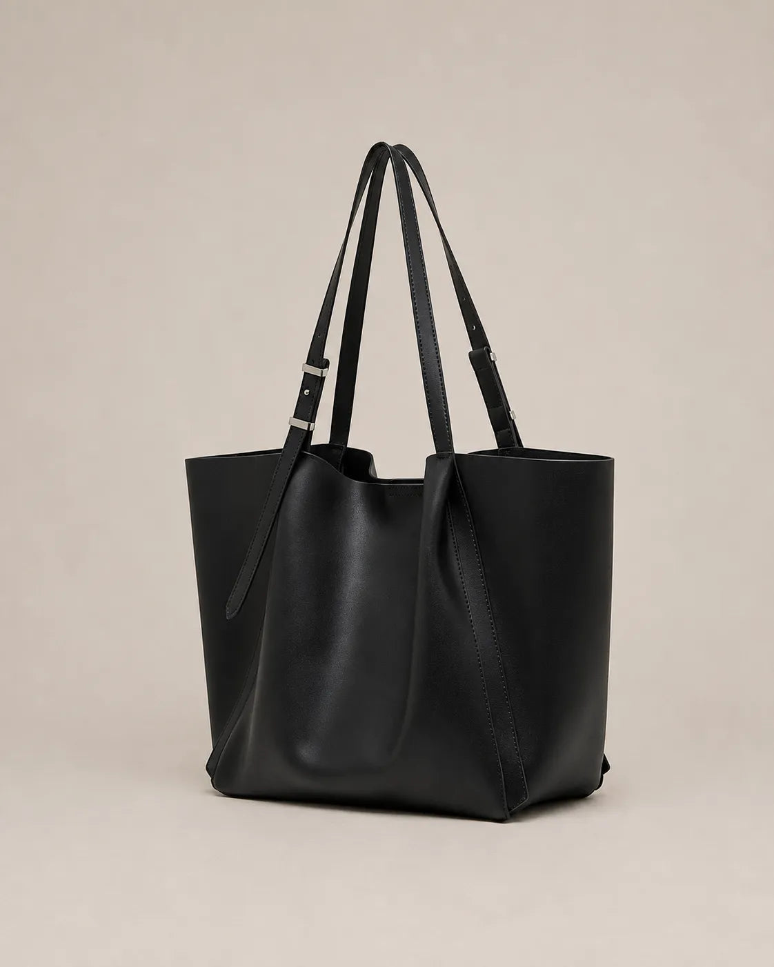 Angled view of the Rosalind oversized genuine leather tote bag in black showing the spacious silhouette and integrated handles.