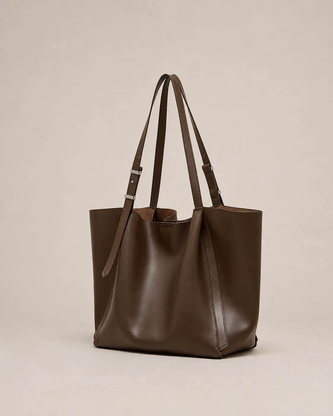 Angled view of the Rosalind oversized genuine leather tote bag in coffee showing the spacious silhouette and integrated handles.