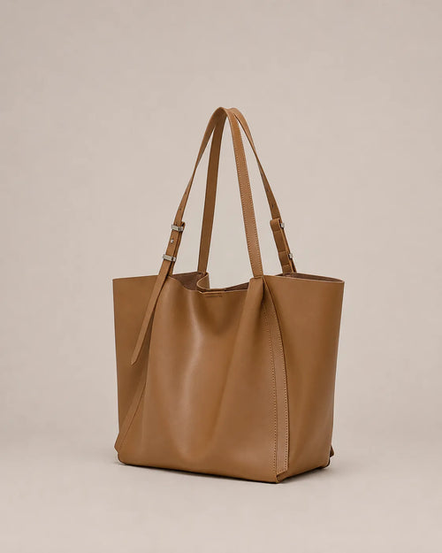 Angled view of the Rosalind oversized genuine leather tote bag in brown showing the spacious silhouette and integrated handles.