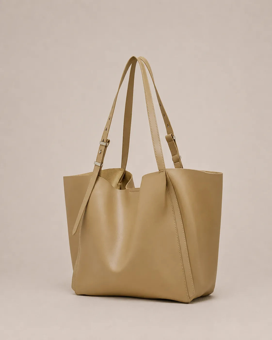 Angled view of the Rosalind oversized genuine leather tote bag in apricot showing the spacious silhouette and integrated handles.