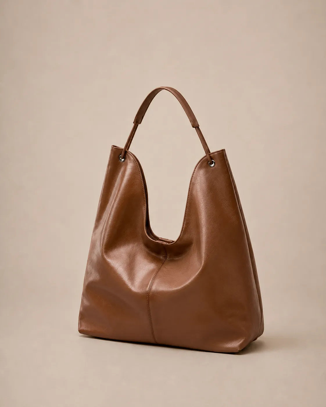 Angled view of the Colette leather hobo tote bag in brown highlighting its relaxed shape and premium leather finish.