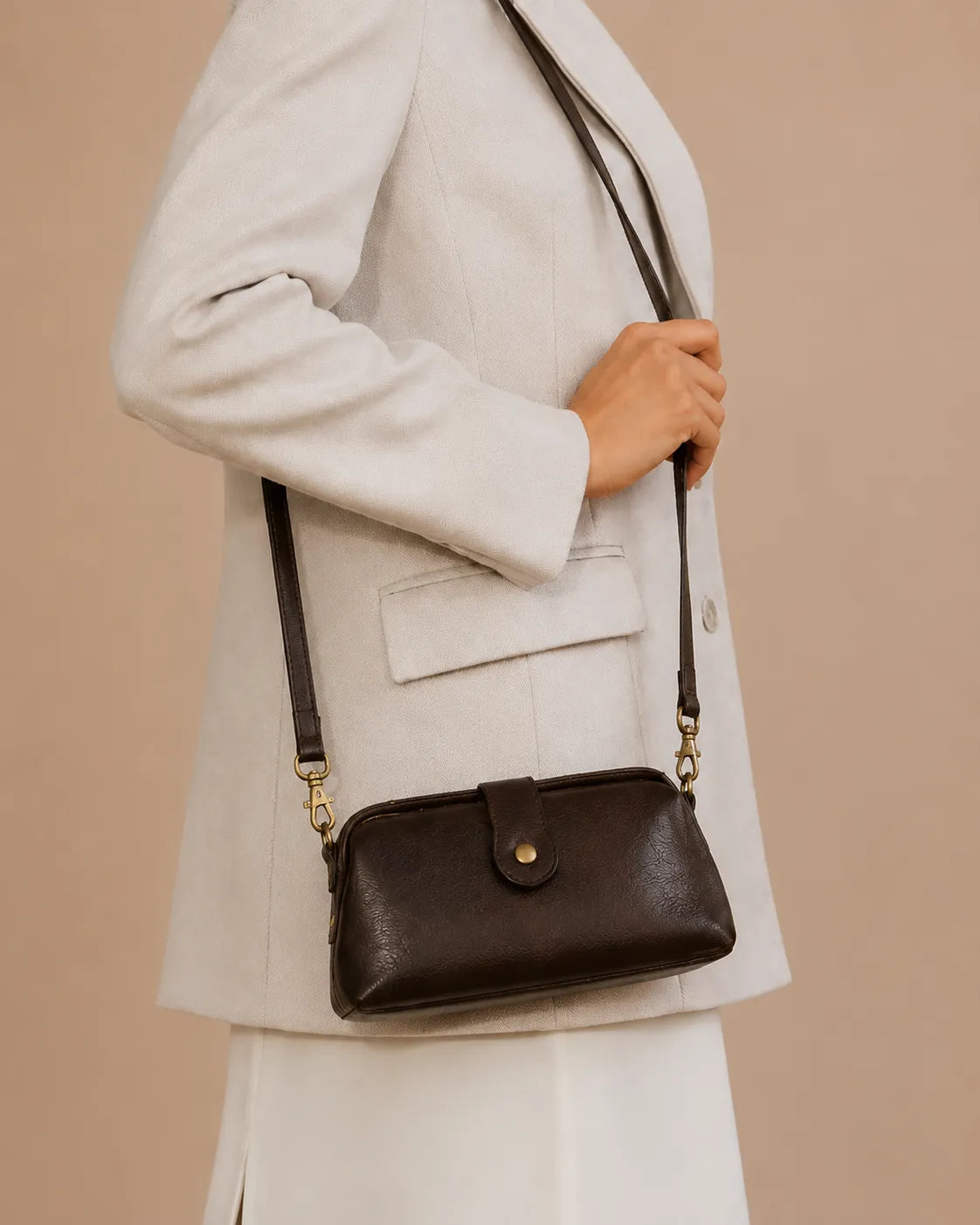 Model wearing the Eloise leather crossbody bag in dark chocolate genuine leather as a crossbody bag for everyday and evening wear.