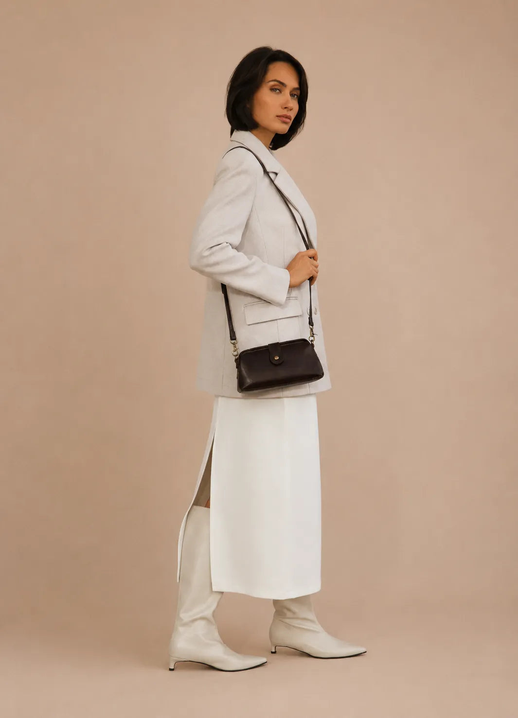 Model wearing the Eloise leather crossbody bag in dark chocolate genuine leather as a crossbody bag for everyday and evening wear.