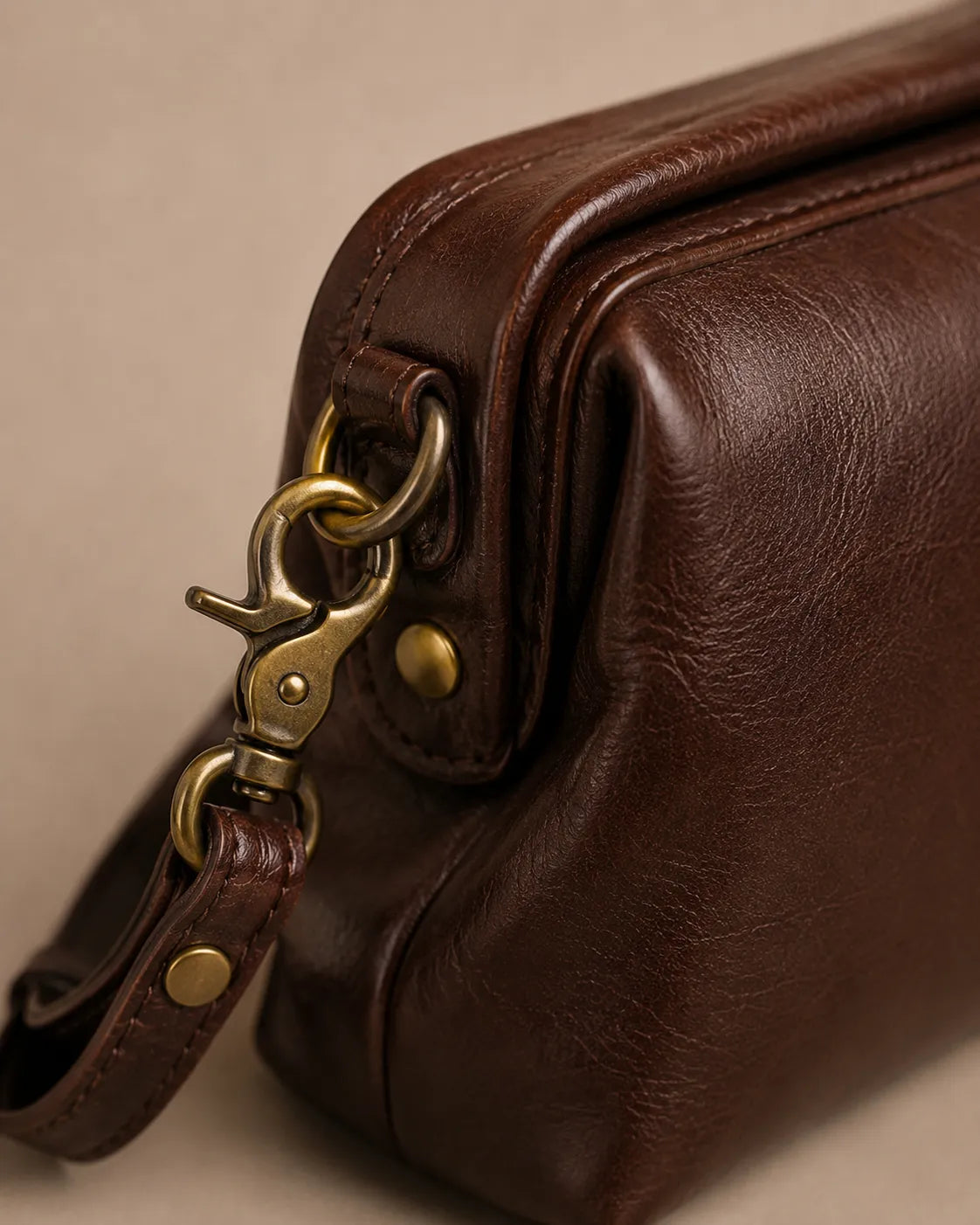 Close-up detail of the Eloise leather crossbody bag in dark chocolate genuine leather showing antique gold-tone hardware.