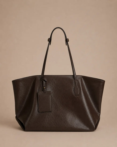 Front view of the Emilia Tote in dark chocolate leather, featuring a spacious silhouette, adjustable shoulder straps and elegant everyday design.