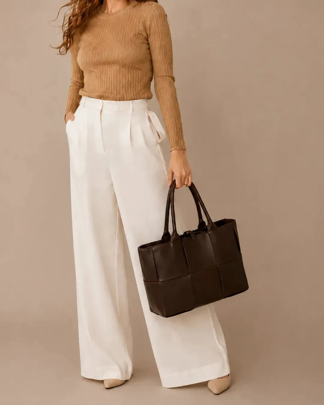Woman holding the Florence oversized woven leather tote bag in chocolate brown genuine leather.