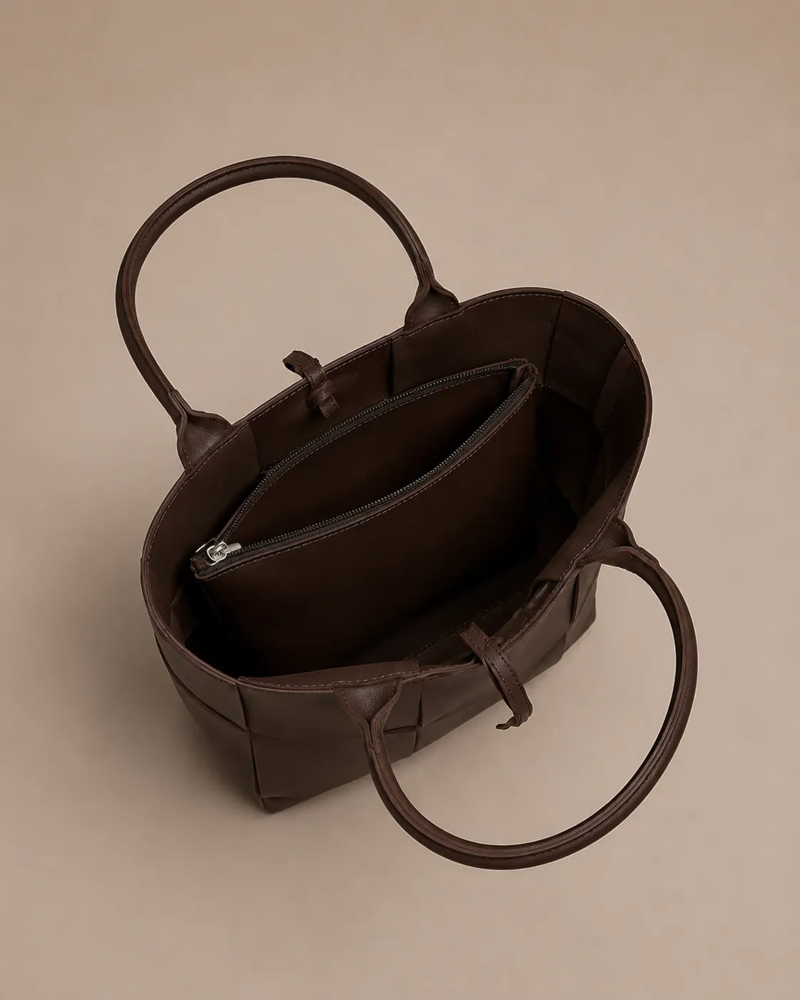 Interior view of the Florence woven leather tote bag featuring a spacious compartment and zipped pocket.