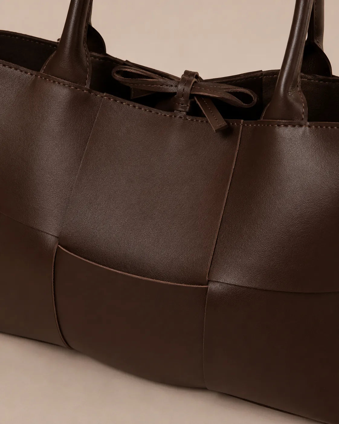Close-up detail of the Florence woven leather tote bag crafted from genuine chocolate brown leather.