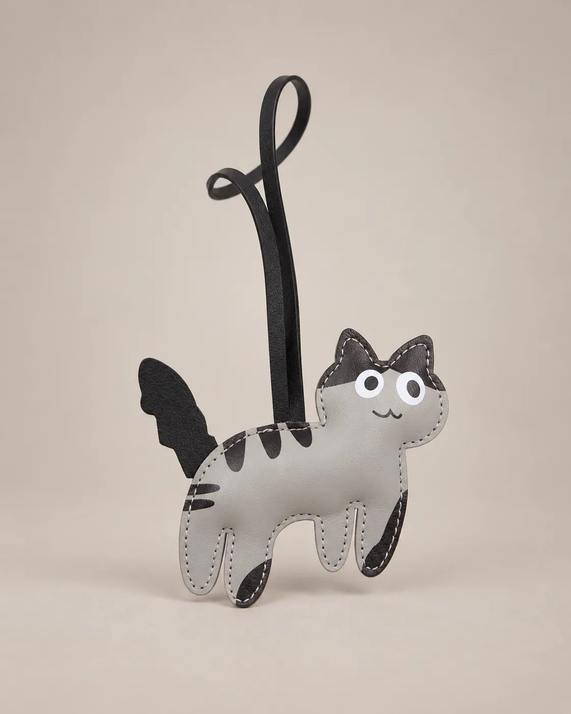 Kitten bag charm in grey PU leather with black stripes, ears and tail and a black hanging strap, by Malena London