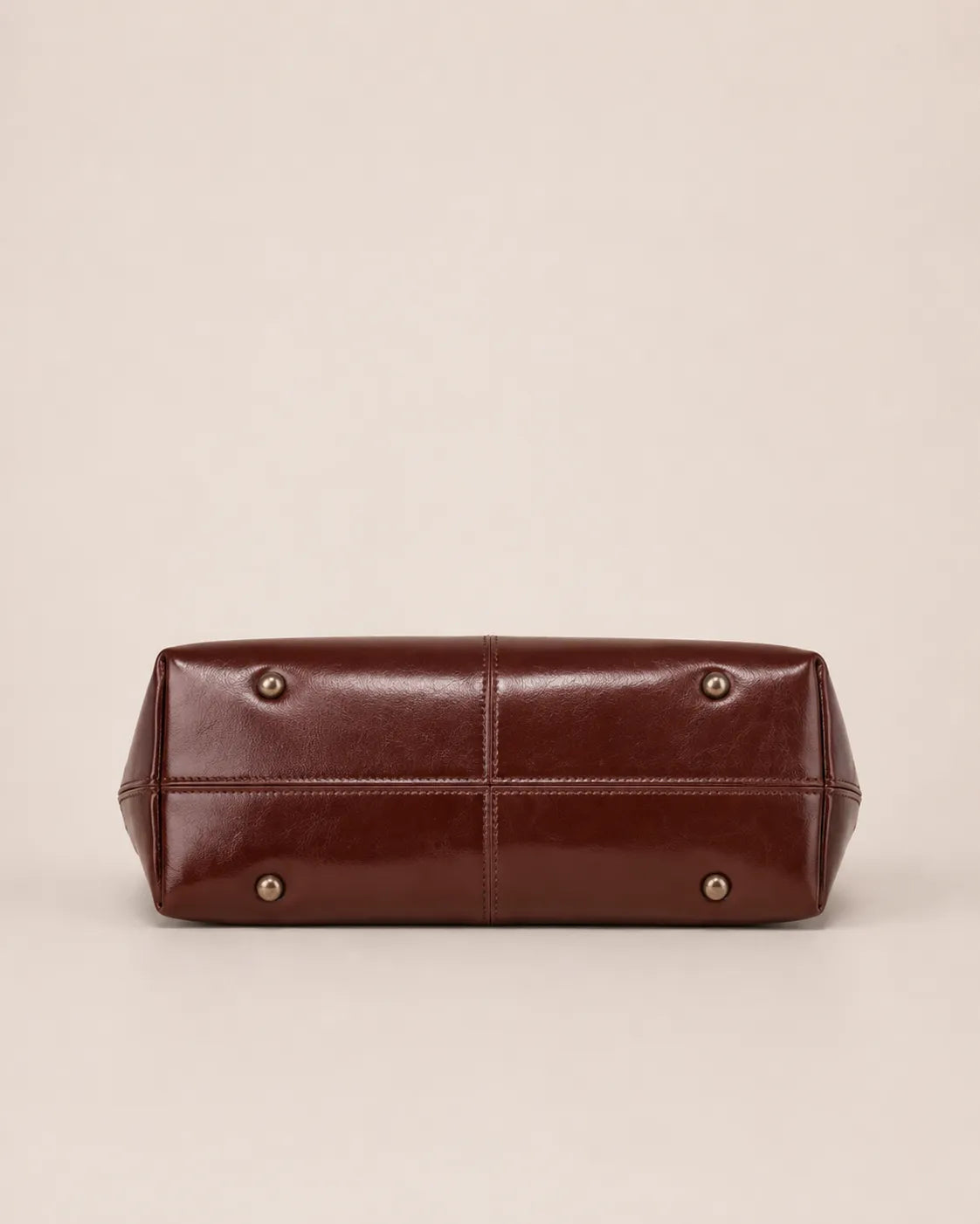 Margaux large leather tote bag bottom view featuring reinforced base and protective metal feet